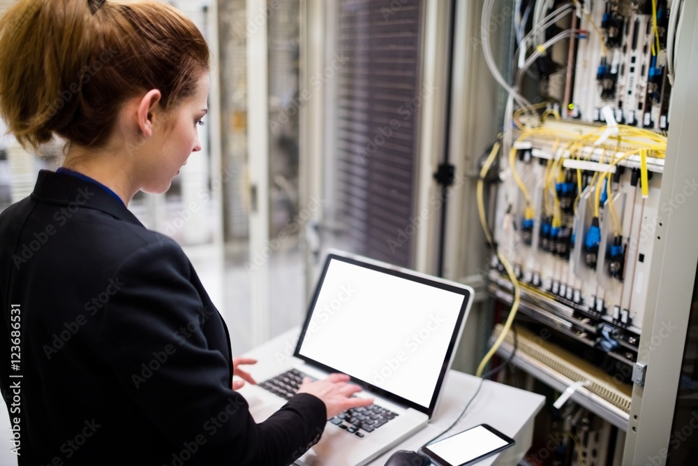 Aufkleber Technician using laptop while analyzing server