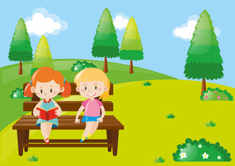 Obraz na płótnie Canvas Two girls reading book in park