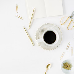 coffee cup, empty diary and golden accessories: tea spoon, pen, clips and scissors on white background. flat lay, top view