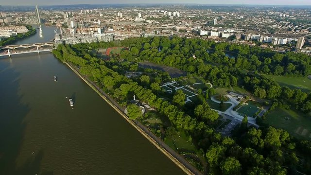 4K Aerial view of Central London featuring the River Thames, Battersea Park and Chelsea Bridge UHD