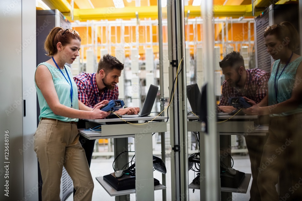 Aufkleber Technicians using laptop while analyzing server