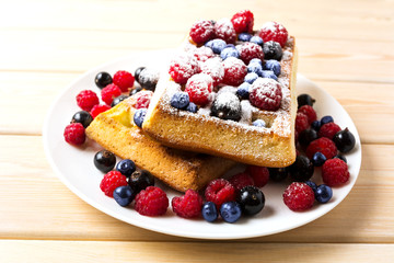 Belgian waffles with blueberry and raspberry powdered by caster