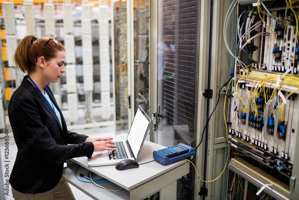 Aufkleber Technician using laptop while analyzing server