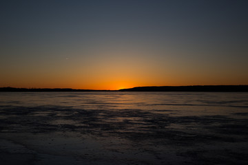 Sunset over a frozen lake in winter