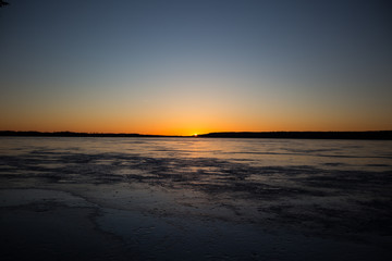 Sunset over a frozen lake in winter