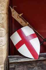 Medieval England flag shield and weapon resting on the wall side 