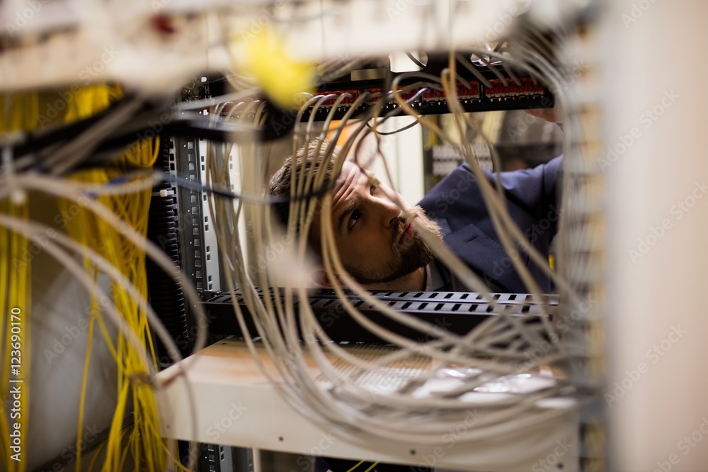 Poster technician checking cables in a rack mounted server