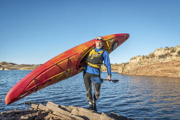 carrying river kayak on lake shore