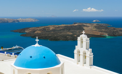Blue-domed chapel with ochre bell tower in Oia