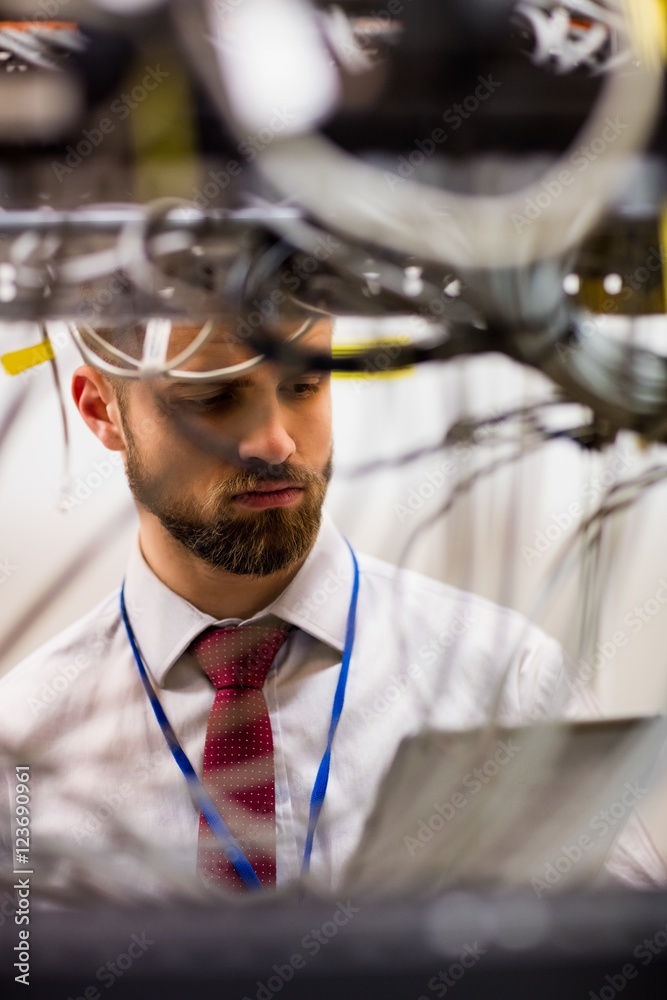 Poster Technician using digital tablet while analyzing server