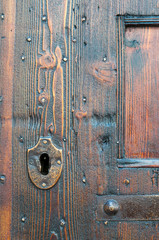 Fototapeta na wymiar Closeup view of a metal keyhole of an old wooden door