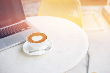 Laptop and coffee cup on wooden table