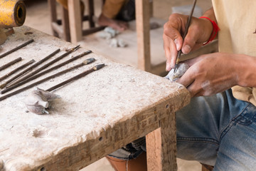 Craftsman using a tool on a marble to carve a statue elephant