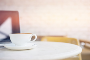 Laptop and coffee cup on wooden table