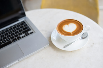 Laptop and coffee cup on wooden table