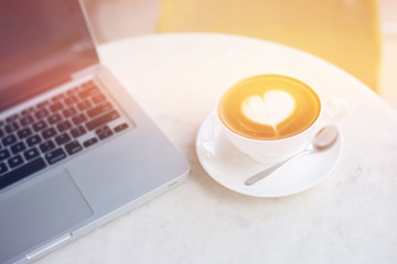 Laptop and coffee cup on wooden table
