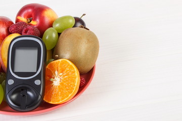 Glucometer and fresh fruits on plate, diabetes and healthy nutrition, copy space for text