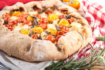 delicuious pie with cherry tomatoes, feta cheese herbs