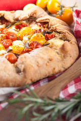 delicuious pie with cherry tomatoes, feta cheese herbs