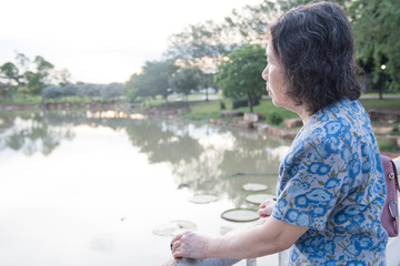 portrait of lonely senior asian woman in garden