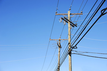 power pole under blue sky, vertical composition