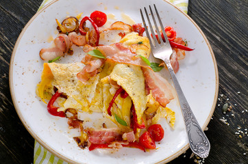 Eggs, bacon and cherry-tomatoes  on dark wooden table.