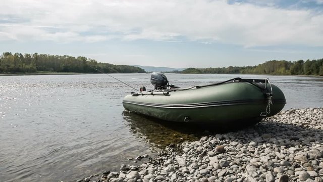 the green boat of pvc with the water-jet engine on the river bank