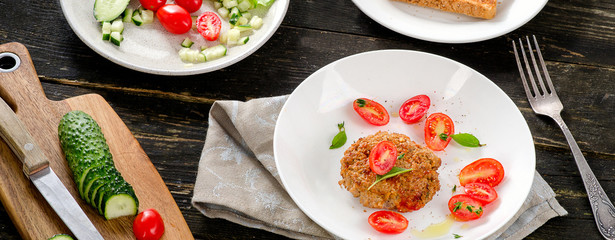 Meatball with fresh vegetables on a wooden table.
