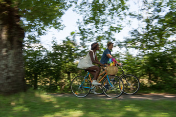 Naklejka premium Young multiethnic couple having a bike ride in nature
