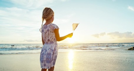 Cute young girl with American Flag on beach at sunset - Powered by Adobe