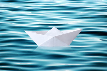 Paper boat floating on rippled water