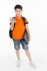 Happy asian boy using cell phone and holding laptop .