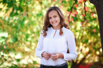 Young beautiful woman. Beauty smiling teenager girl in autumn park