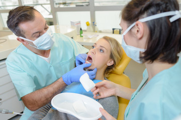 Fototapeta premium Dentist inspecting female patient