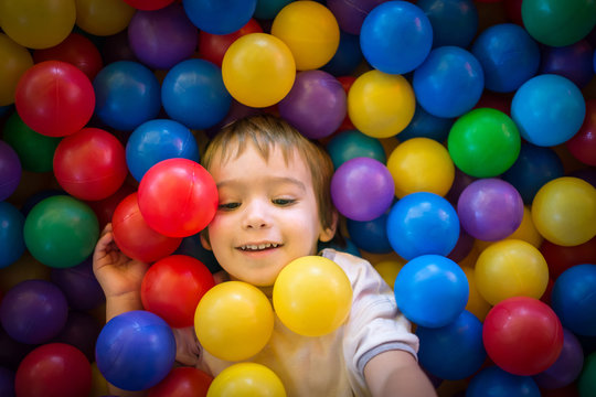 Happy cute child playing and having fun at kindergarten with col