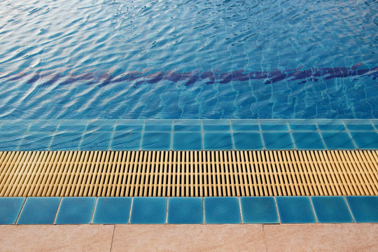 the edge of swimming pool with blue water