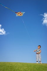 Little boy on summer vacation having fun and happy time flying k