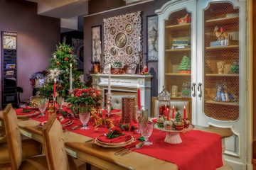 Served table in empty room decorated for Christmas. Thanksgiving table, decorated with fresh pine and candles.