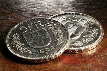 Swiss 5 FR silver coins on rustic wooden background