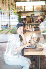 Hipster asian woman using laptop computer.