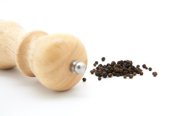 pepper mill of wood with peppercorns
