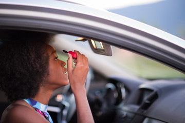 a young African-American woman makeup in the car