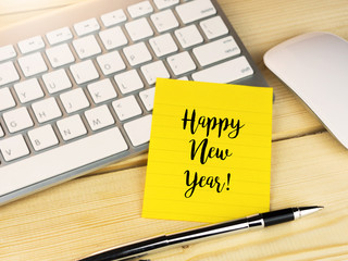 Happy new year on sticky note on office work desk


