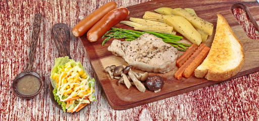 Home made ,Pork steak and mixed vegetables on butcher served served with side dish as parmesan cheese bread ,sausage ,shiitake fresh mushroom soup and salad.