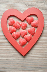 Fototapeta na wymiar Valentine's Day. Wooden heart filled with sugar heart candy