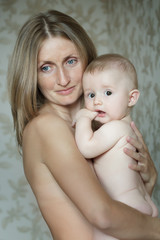 Family portrait of blue-eyed mother holding her baby child