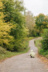 Little girl in the autumn park. pathway