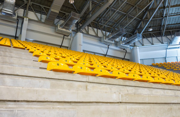 Fototapeta premium empty yellow seats at indoor stadium