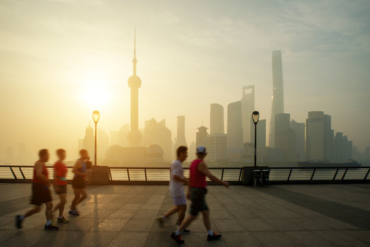 People running at Huangpu River riverside with Shanghai, China