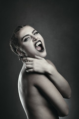 Fototapeta premium Female vampire showing fangs